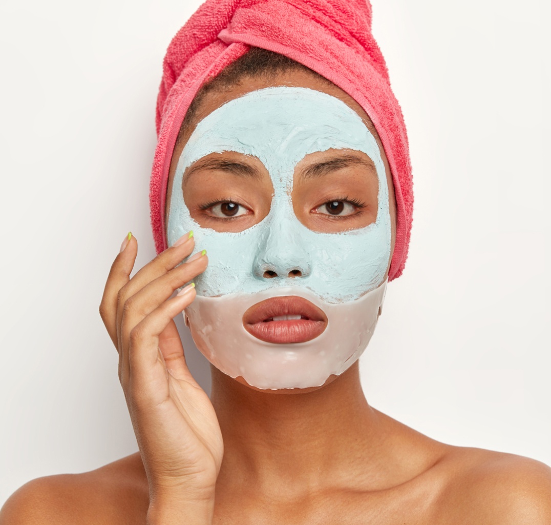calm-relaxed-beautiful-woman-wears-facial-clay-mask-cares-about-wellness-and-good-appearance-wears-pink-soft-towel-on-head-stands-naked-against-white-wall-female-cleanses-face-purifies-skin.jpg